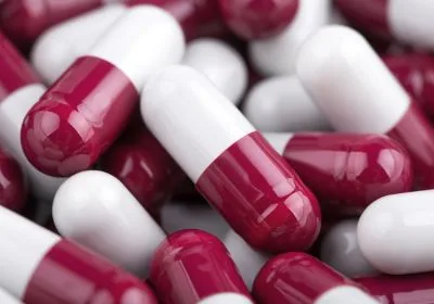 Close up of maroon and white capsules.
