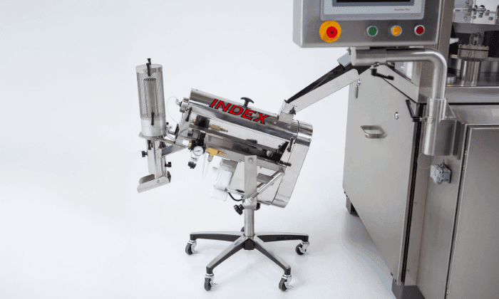 Stainless steel automated capsule filling machine labeled "INDEX" for high-volume, precise production and compliance.