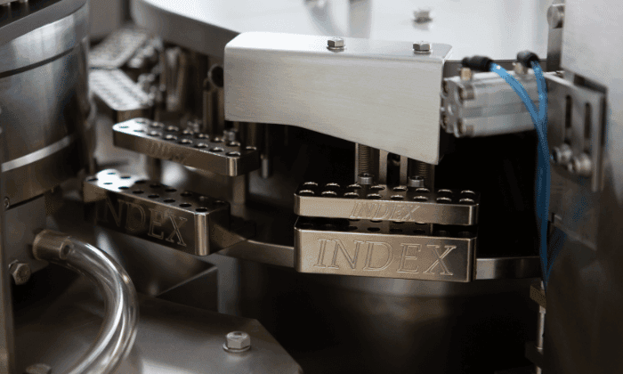 Close-up of an INDEX stainless steel capsule filling machine, emphasizing advanced manufacturing and reliability.